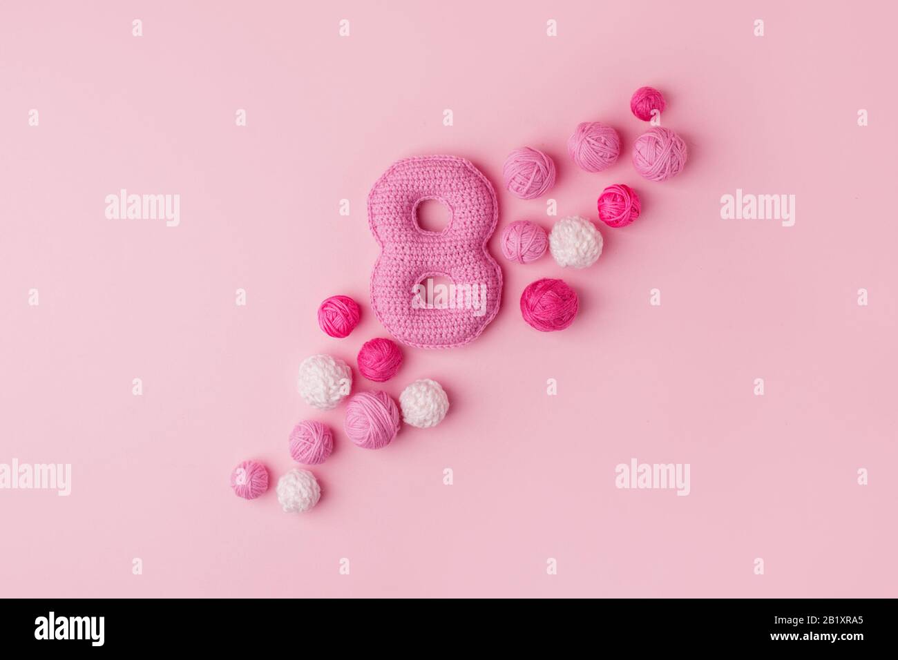 Happy International Women's Day feiern am 8. März, GLÜCKWUNSCHKARTE. Handgefertigtes Häckchen Rosa Nummer acht und Garnball, minimales Konzept für se Stockfoto