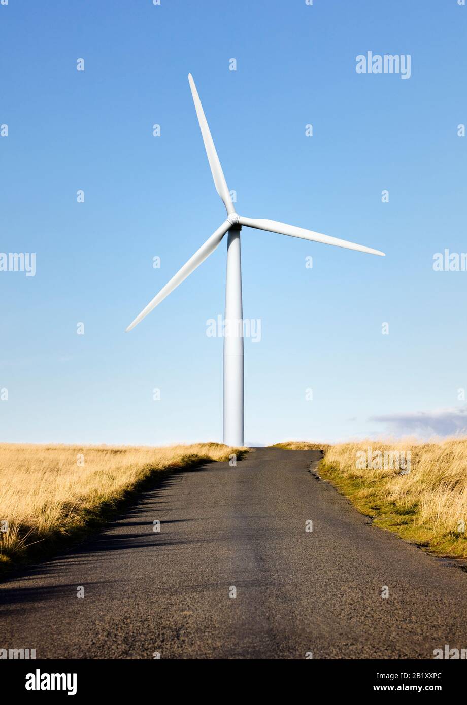 Eine Windenergieanlage am Ende einer Landstraße Stockfoto