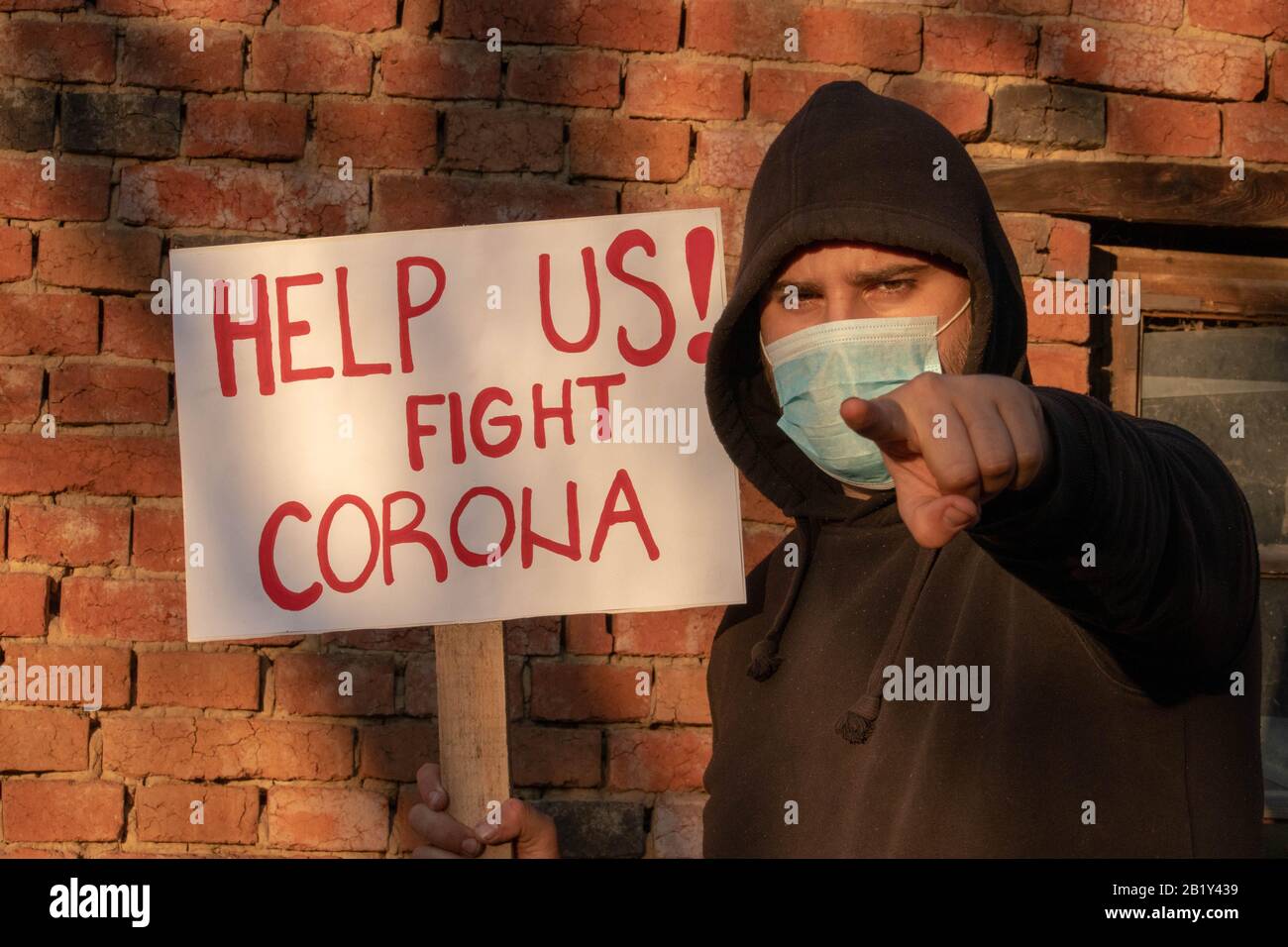 Mann mit Banner ' helfen Sie uns! Kampf gegen die Proteste von Coronavirus Und Aufruf von Regierungen zur Bekämpfung des Corona-Virus. Person ermutigen Wissenschaftler, pande aufzuhalten Stockfoto