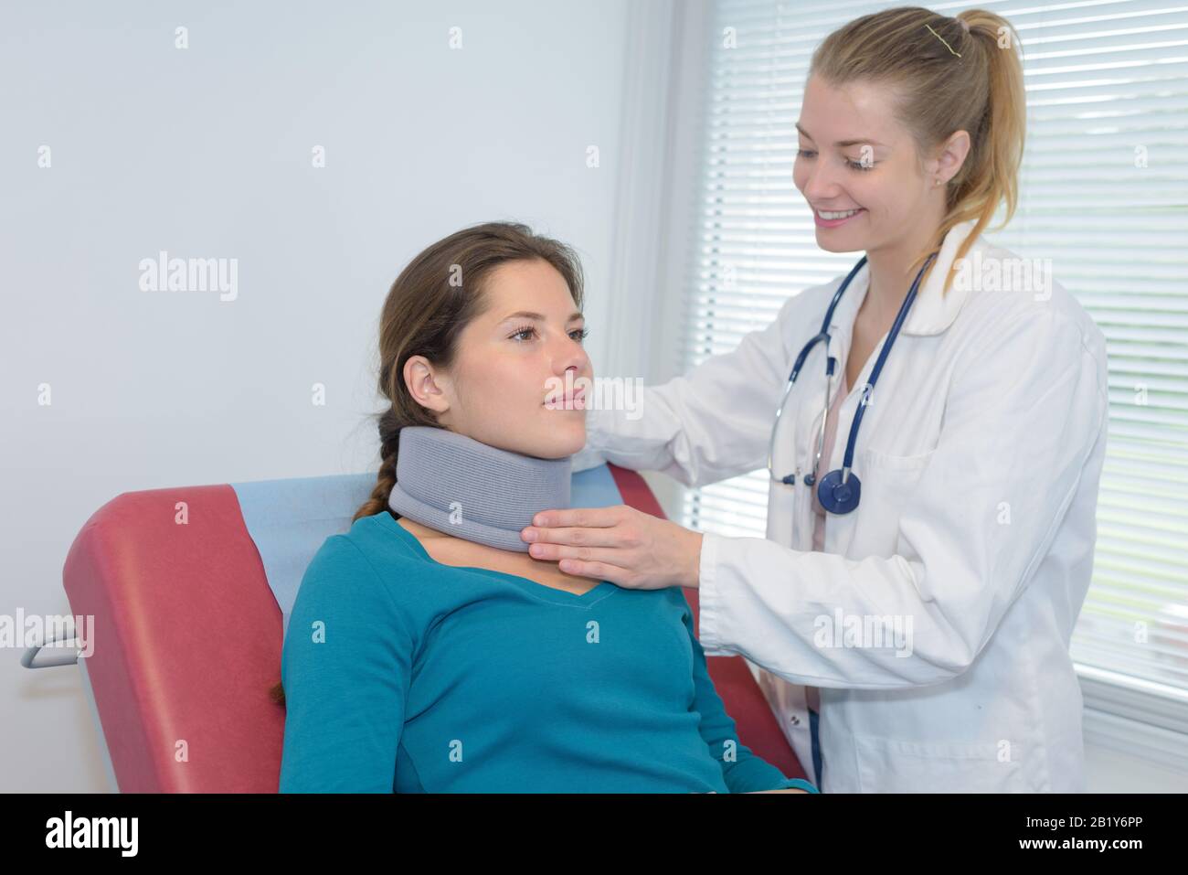 Arzt, der die Nackenstütze des Patienten einstellt Stockfoto