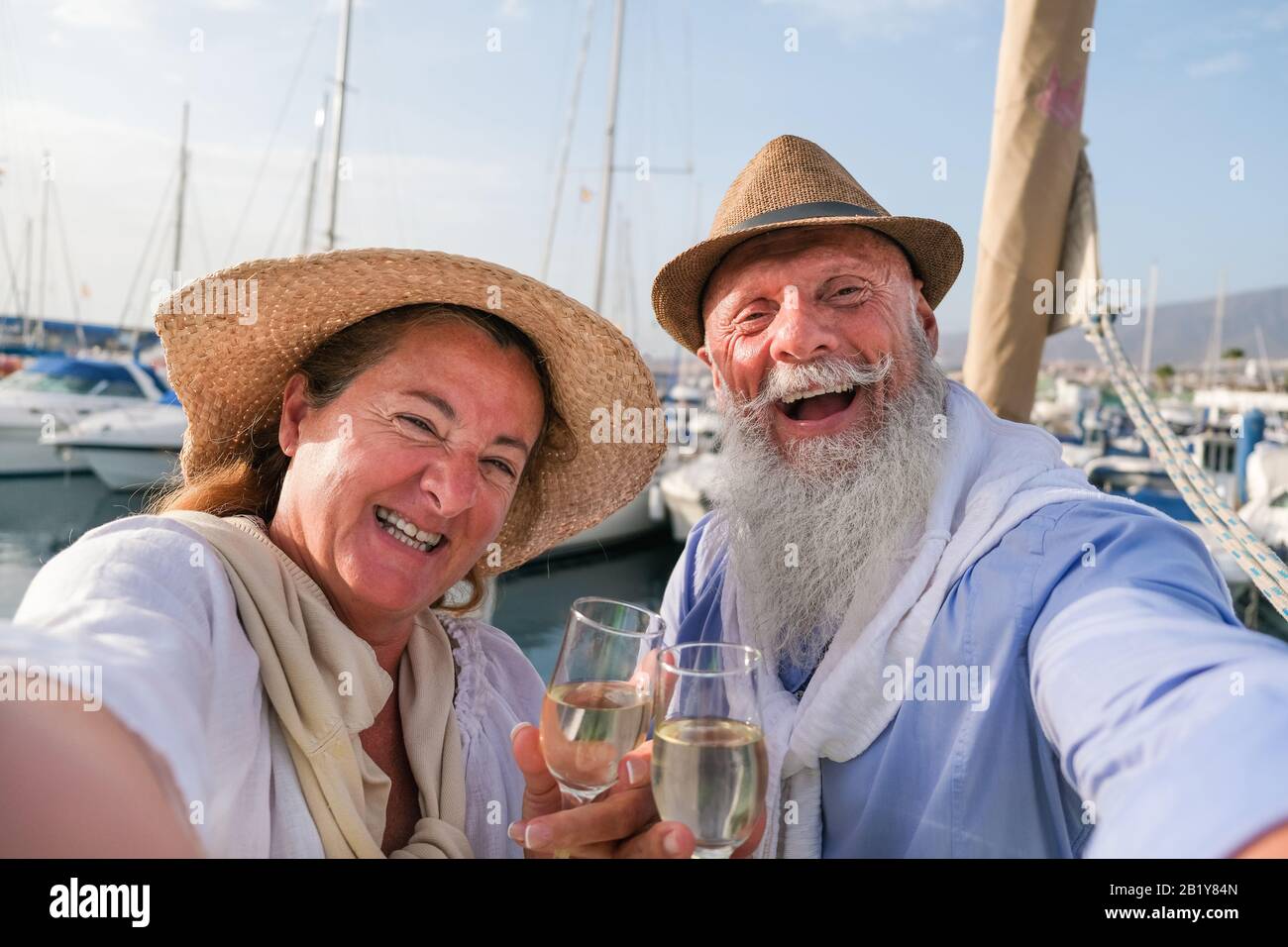 Fröhliches älteres Paar macht selfie, jubelt mit Champagner auf einem segelboot während des Jubiläumsurlaubs - Fröhlicher älterer Lebensstil, Liebe, Reisen und Holid Stockfoto