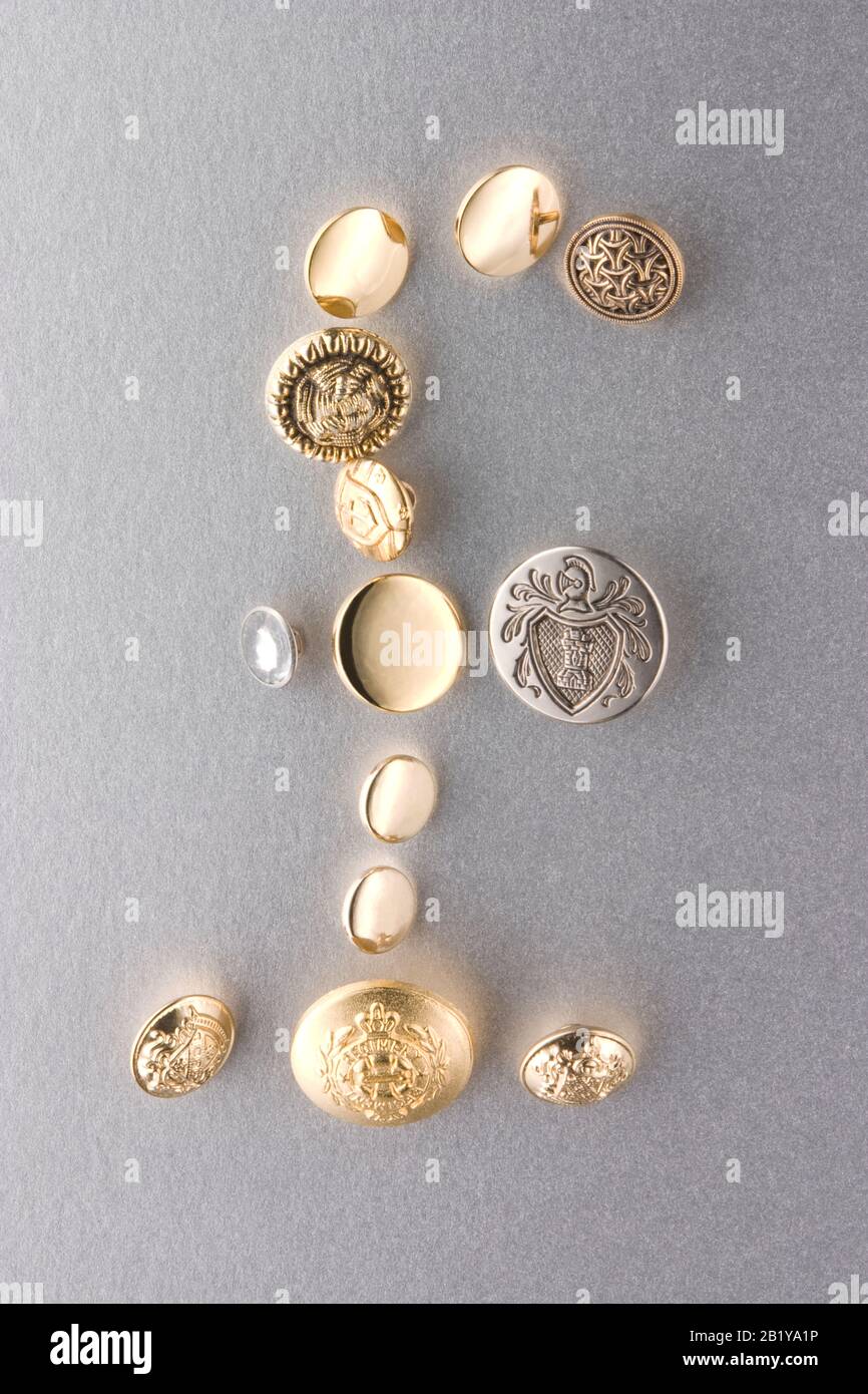 Pfund Schild Bank of England Pfund Sterling Symbol aus Gold-, Gold- und Silberknöpfen auf leicht strukturiertem mattsilberfarbenem Hintergrund Studio Stillleben Stockfoto