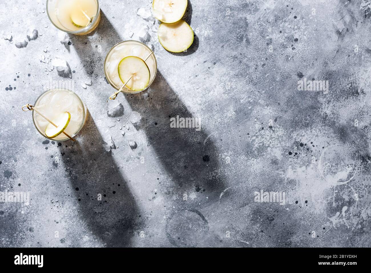 Ein kurzes Glas erfrischendes Sodawasser aus Birne oder ein Cocktail auf grauem Betonhintergrund. Alkoholfreies Sommergetränk. Horizontale Ausrichtung Stockfoto