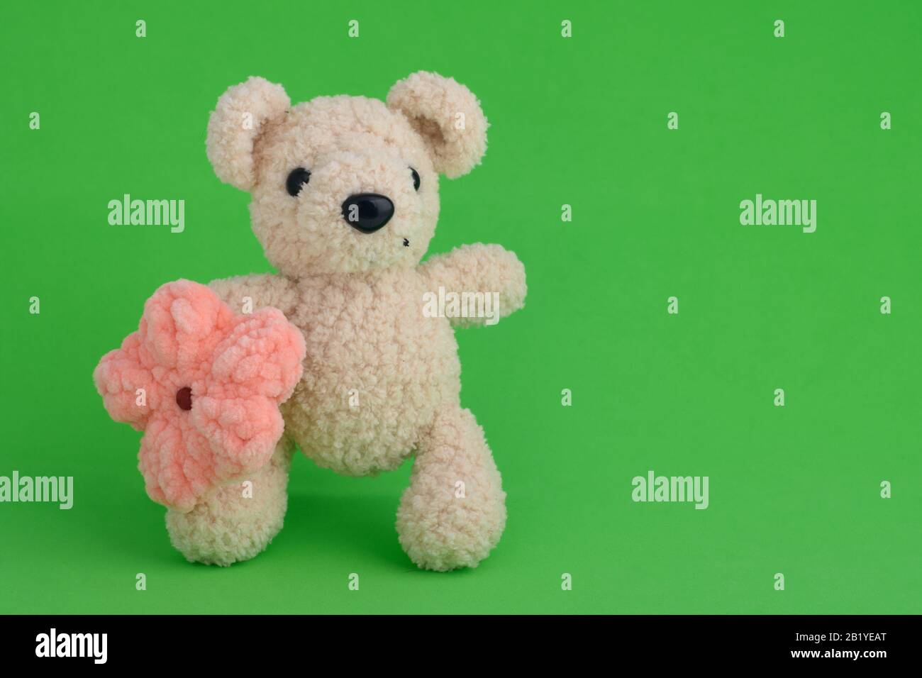 Gestrickte pinkfarbene Maus auf grünem Hintergrund Stockfoto