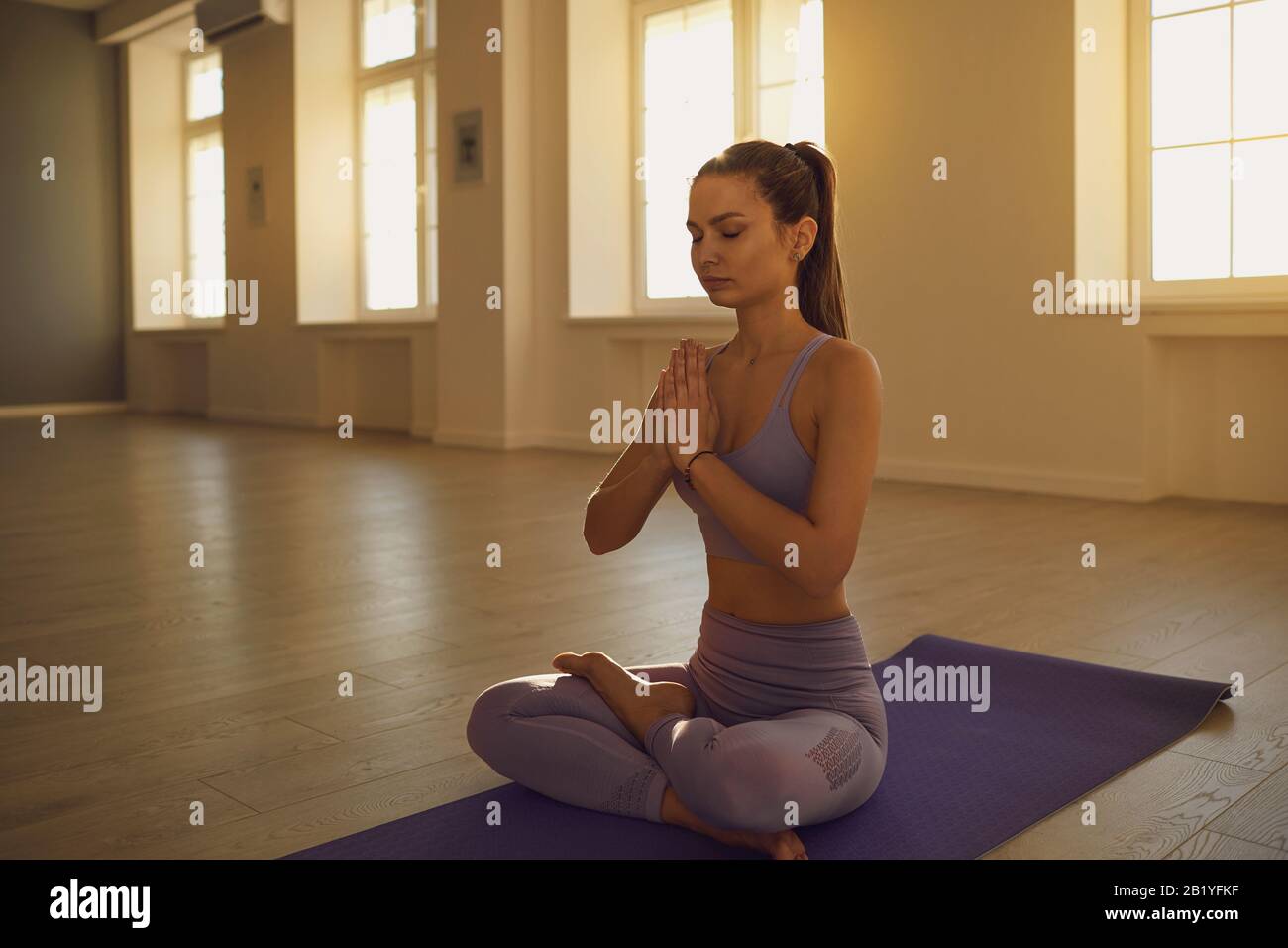 Das Yoga der Mädchen in lotus-position entspannt sich am Morgen bei Sonnenaufgang im Klassenzimmer. . Stockfoto