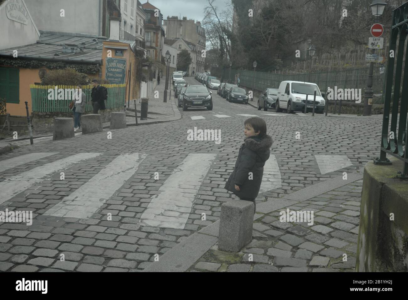 Kleiner Junge auf einem gepflasterten Gehweg in Paris, pasakdek Stockfoto