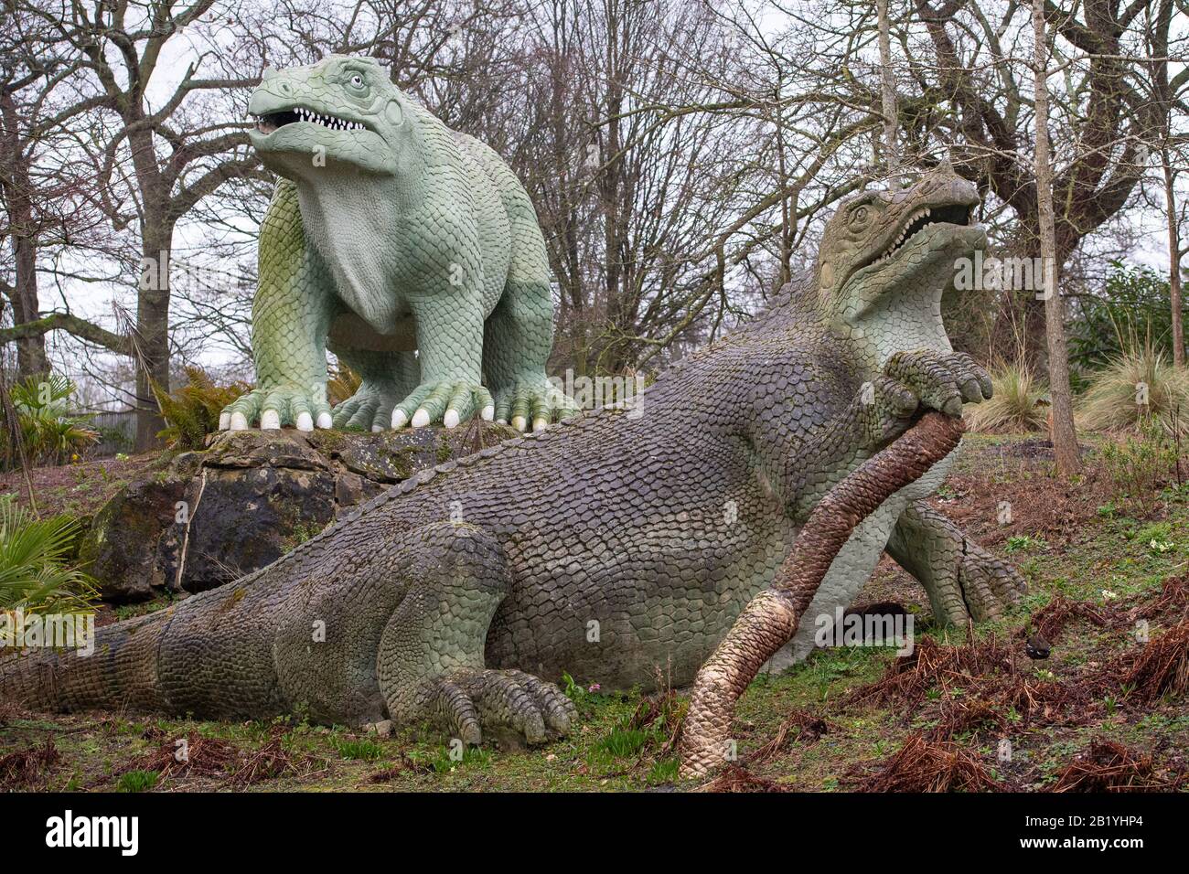 Allgemeiner Blick auf zwei Iguanadon Skulpturen, Teil der Crystal Palace Dinosuars, im Crystal Palace Park, London. Die in den 1850er Jahren errichteten 30 Grade-I-Statuen wurden in das "Heritage at Risk Register" Des Historischen Englands aufgenommen, nachdem Experten große Risse an den Körpern und Gliedmaßen und Gefahr des Verlustes von Zehen, Zähnen und Schwänzen gefunden hatten. Stockfoto