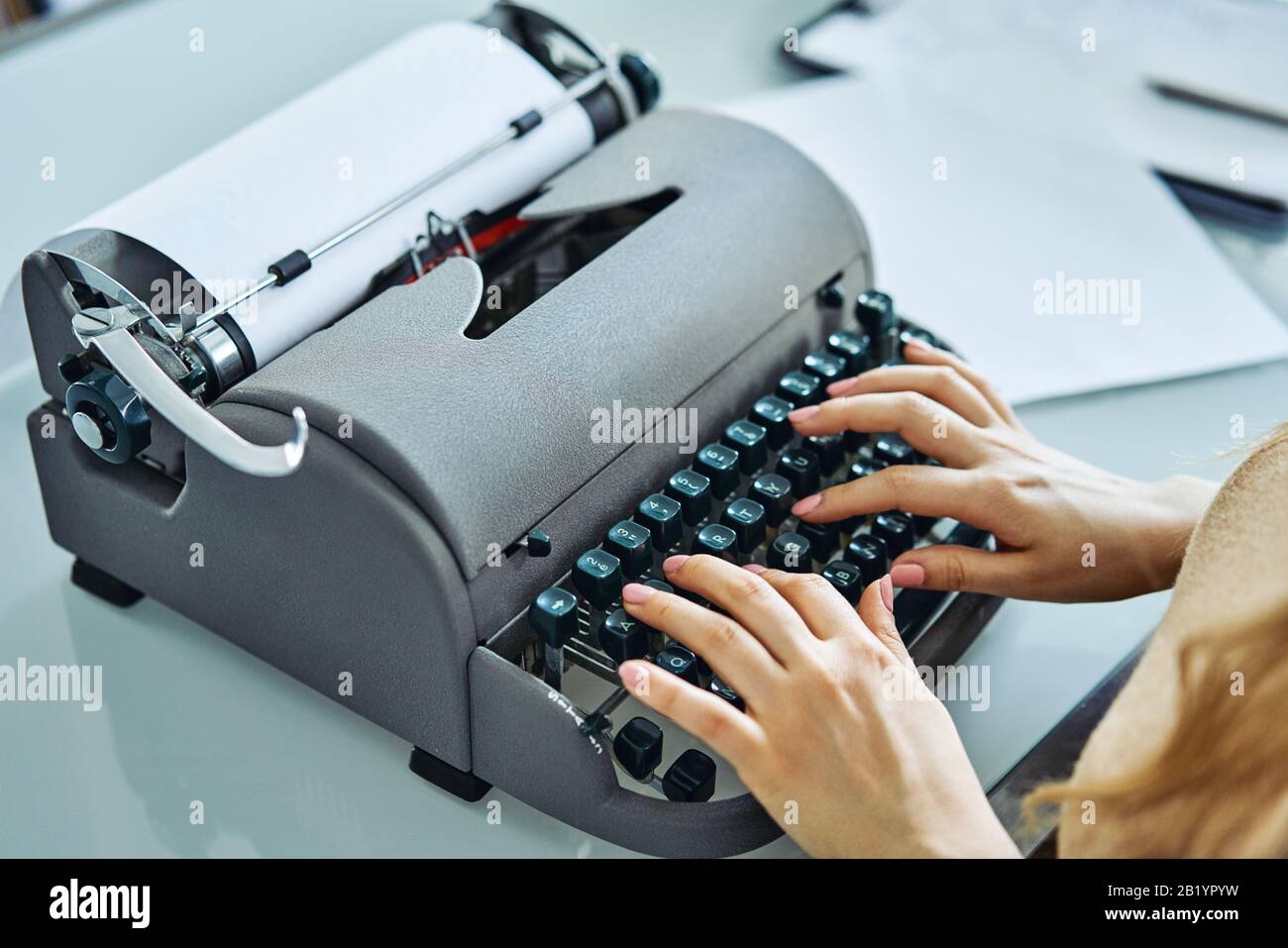 Nahaufnahme der Frau, die mit alter Schreibmaschine tippt Stockfoto