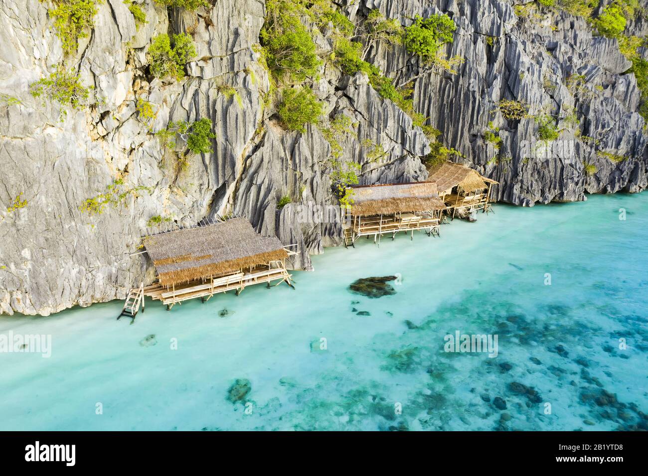 Blick von oben, atemberaubender Luftblick auf einige von felsigen Klippen umgebene, von einem türkisfarbenen, kristallklaren Meer umgebene, Zimmer. Malwawey Coral Garden. Stockfoto