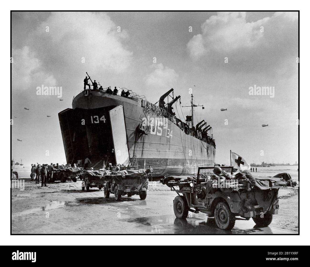 D-Day+6 Operation des zweiten Weltkriegs Overlord amerikanische Opfer US Navy LST-134 und LST-325 in der Normandie gebetet Frankreich, während Jeeps, die entlang des Invasionsstrandes fahren, Opfer auf die Wartschiffe bringen, 12. Juni 1944 WW2 Zweiter Weltkrieg Stockfoto