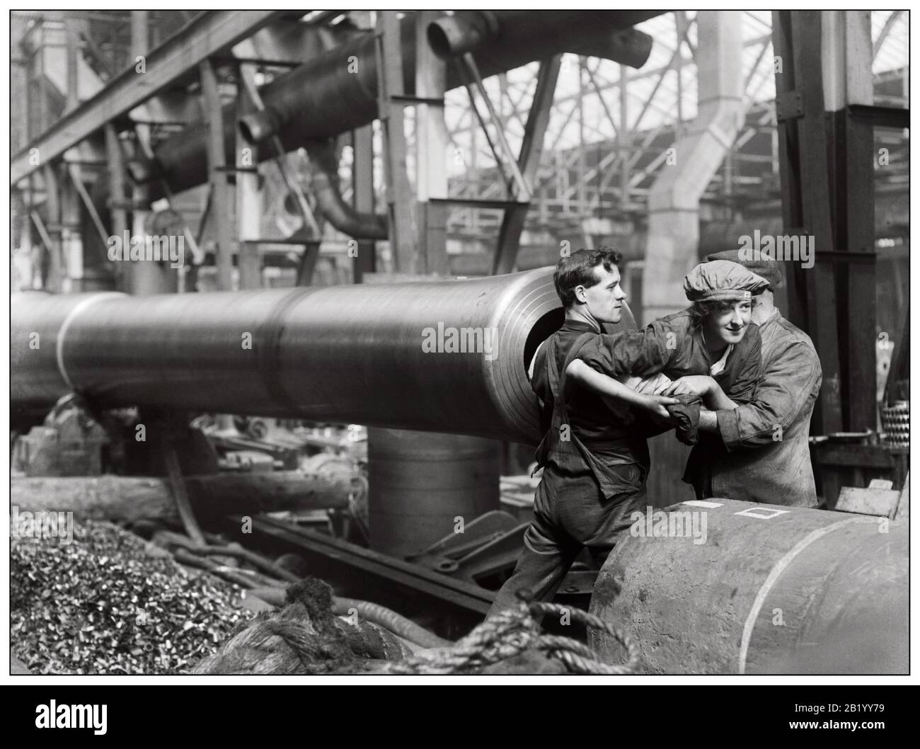 Munition WW1, ein weiblicher Munitionsarbeiter wird in das Fass einer 15-Zoll-Marinekanone gehoben, die während des Ersten Weltkriegs in den Ordnance Works, Coventry, Großbritannien, hergestellt wurde, um das Rifling zu reinigen. 1. Weltkrieg Die Reinigung Des Marinestützenrohrs Des Great war Naval Stockfoto