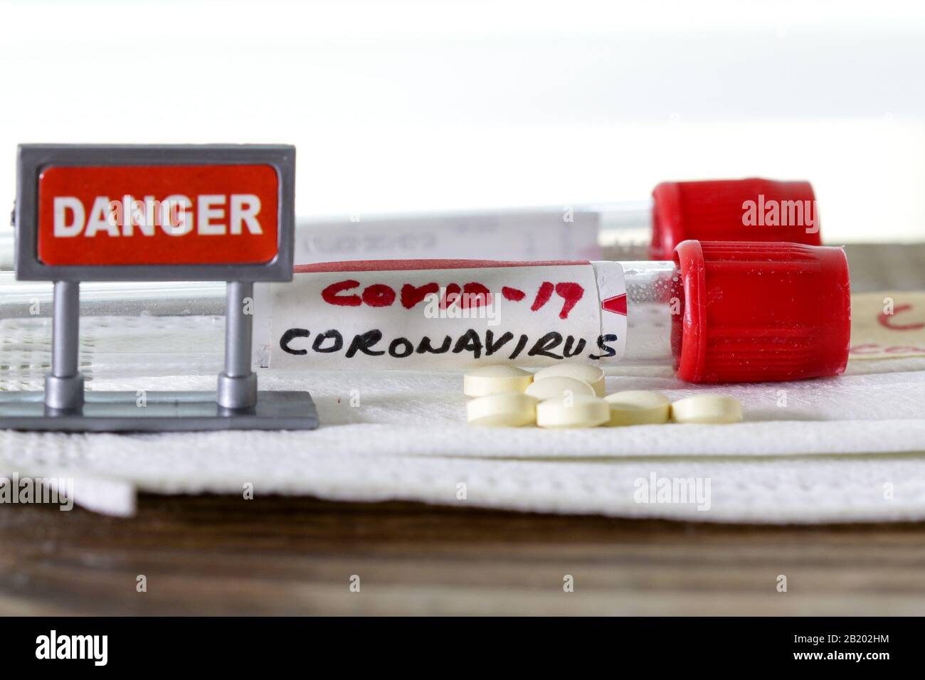 Coronavirus alias COVID -19 auf Blutschlauch mit Pillen und Gefahrzeichen Stockfoto