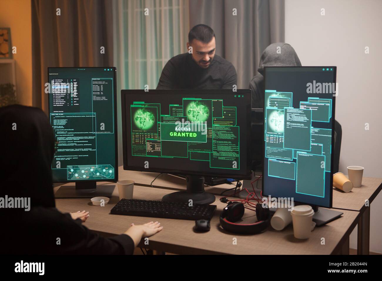 Glücklicher Cyberterrorist, nachdem er eine Firewall gehackt und Zugriff gewährt hat. Cyberterroristinnen. Stockfoto