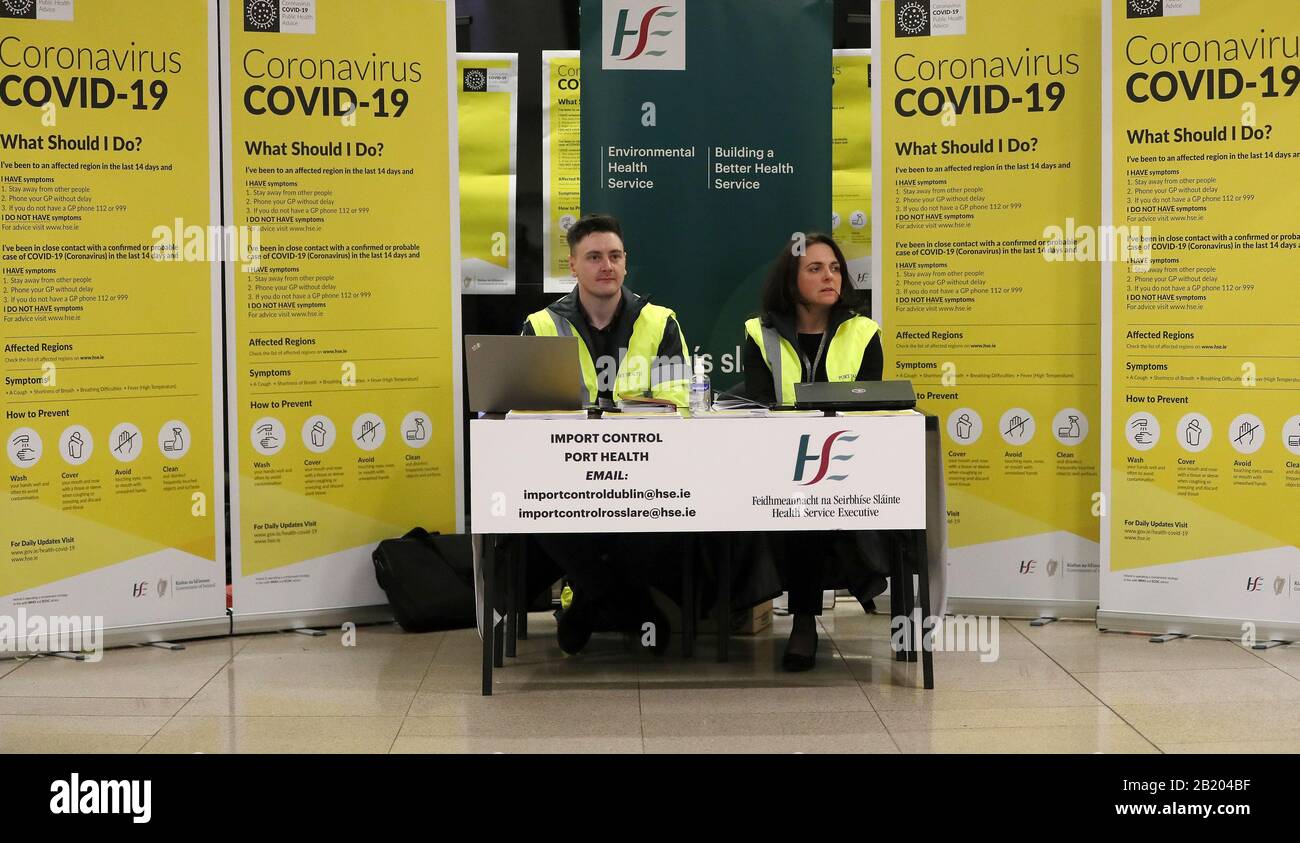 HSE-Mitarbeiter, die die öffentliche Aufklärungskampagne für COVID-19 (Coronavirus) in der Gepäckhalle von Terminal 2 am Flughafen Dublin aktivieren. Stockfoto