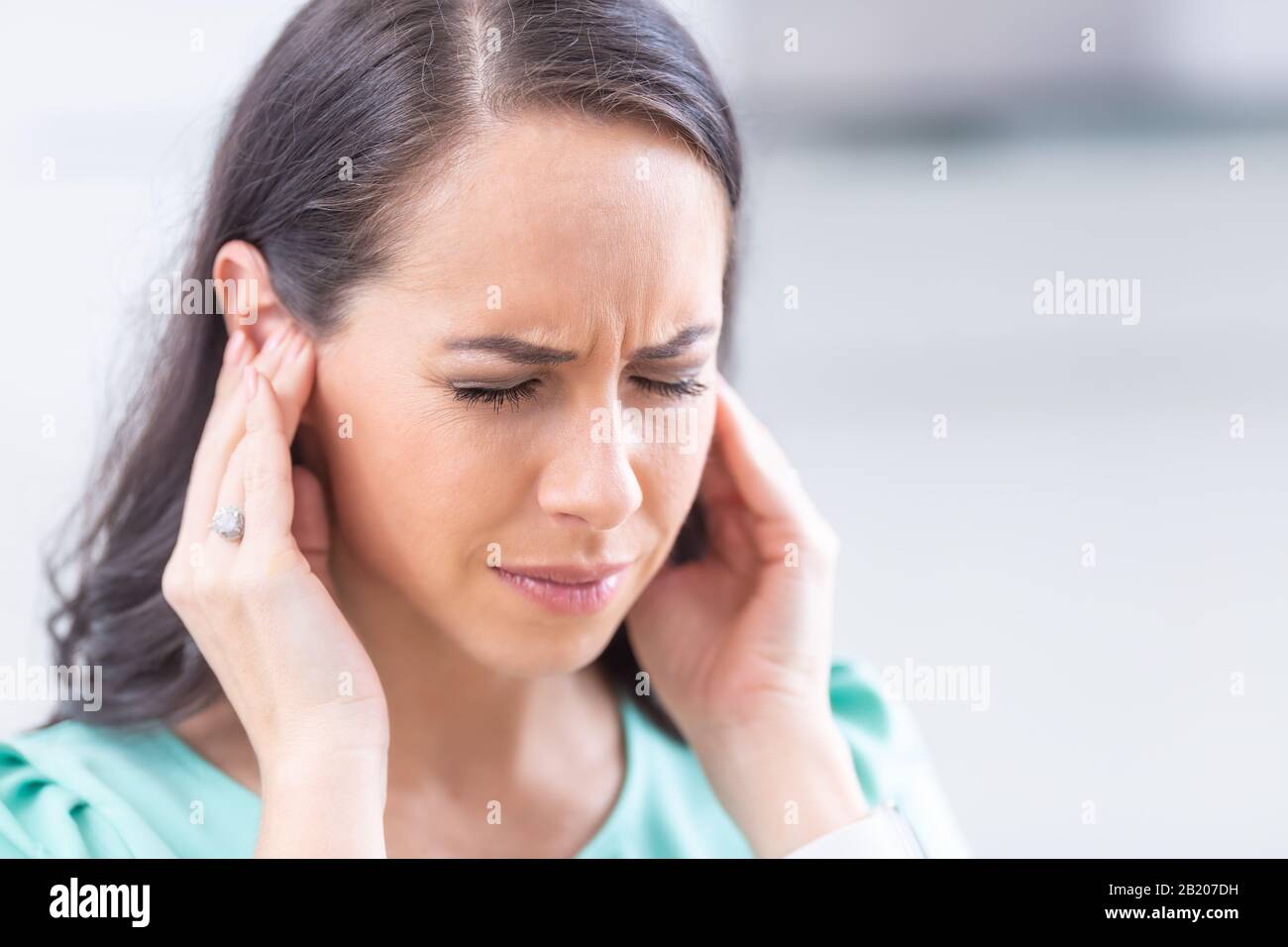 Junge Frau hat Kopfschmerzen Migräne Stress oder Tinnitus - Lärm Pfeifen in  ihren Ohren Stockfotografie - Alamy