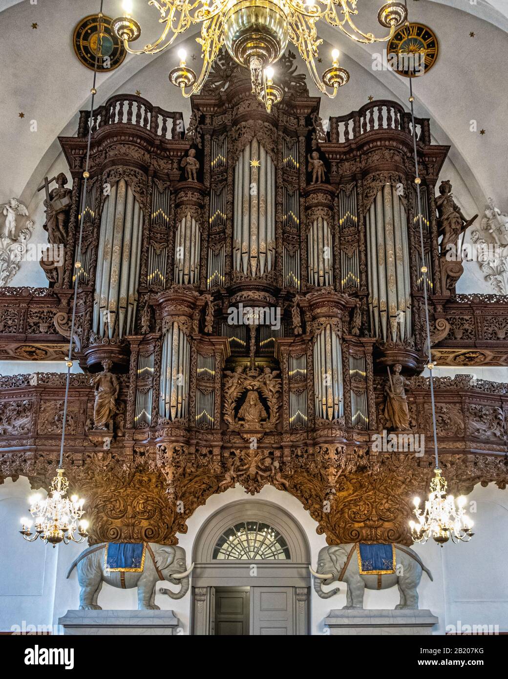 Die Kirche Unseres Erlösers, Vor Frelsers Kirke Interior.Wandmontierte Orgel mit aufwändigen Holzschnitzereien, die von Elefanten in Kopenhagen unterstützt werden Stockfoto