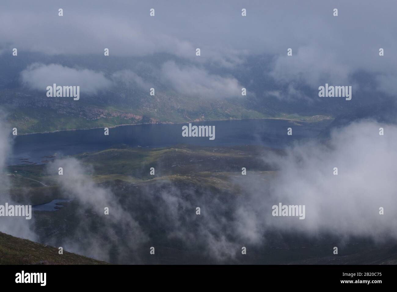 Ein Blick von der Quinag Bergkette hinunter zum Loch Glencoul, Sutherland, Schottland mit wirbelnden weißen, flauschigen Wolken WohleathQuinag Stockfoto