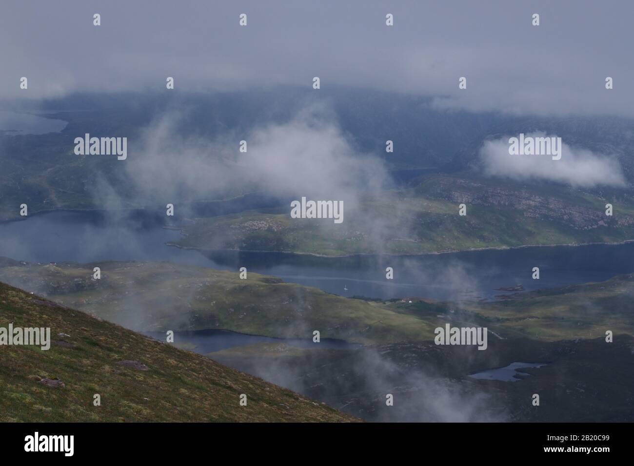 Ein Blick vom Quinag Gebirge hinunter zum Loch Glencoul, Sutherland, Schottland mit wirbelnden weißen, flauschigen Wolken darunter Stockfoto