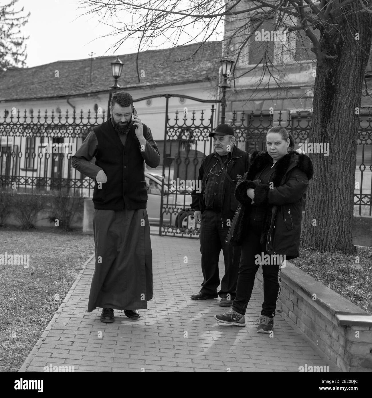 Serbien, 25. Februar 2020: Der orthodoxe Priester begleitet mit Gläubigen in der Kirche der heiligen Apostel Peter und Paul Kirchenhof in Sremski Karlovci Stockfoto
