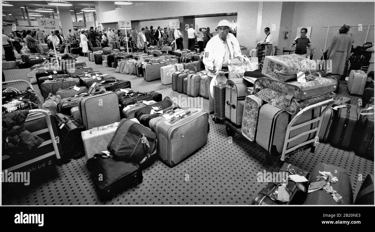 Menschen, die ihr Gepäck suchen, nachdem sie von einem Kreuzfahrtschiff abgebracht wurden, um nach Hause zu gehen, nachdem sie mit Tausenden anderer Senioren auf See in der Karibik umsegelt wurden Stockfoto