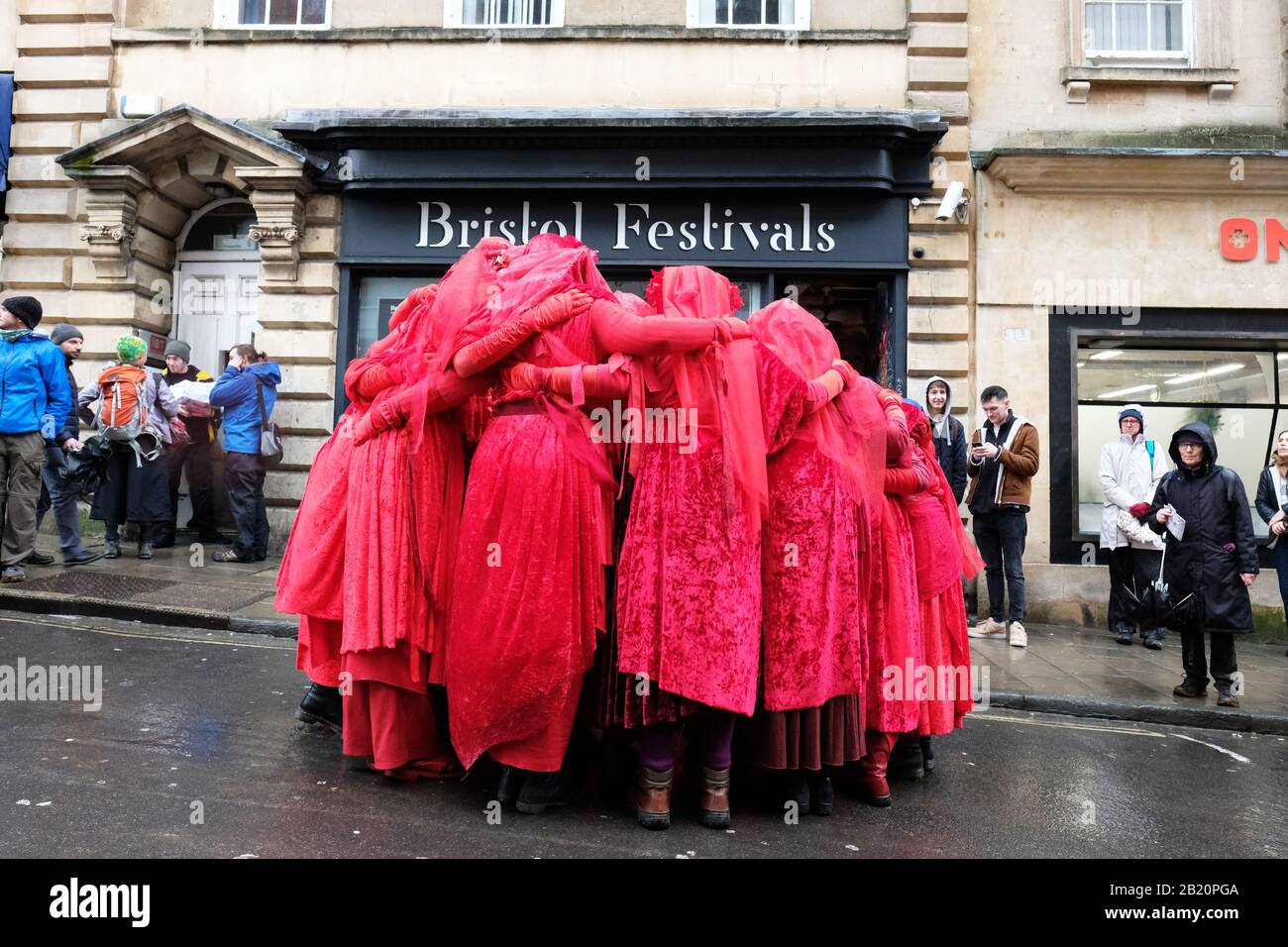 Bristol, Großbritannien - Freitag, 28. Februar 2020 - Extinction Rebellion (XR) Red Brigade Dancers huddle im Zentrum von Bristol vor einer Straßenvorstellung im Rahmen des Bristol Youth Strike 4 Climate march. Foto Steven May / Alamy Live News Stockfoto