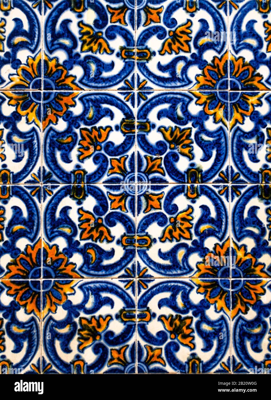 Portugiesische traditionelle Kacheln Azulejos mit blauen und orangefarbenen Blumenmuster auf einem weißen Hintergrund. Stockfoto