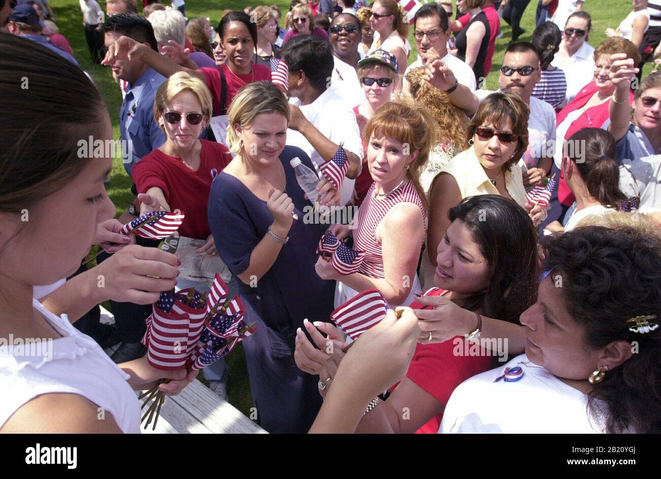 14. September 2001, Austin, Texas: Ein junges Mädchen verteilt kleine amerikanische Flaggen, während sich Menschen aus ganz Zentral-Texas am Freitag im Woodridge Park versammeln, um ihren Patriotismus angesichts der Terroranschläge dieser Woche in New York und Washington zu zeigen. Tausende tauchten auf, um patriotische Lieder zu singen und amerikanische Einheit zu zeigen. ©Bob Daemmrich Stockfoto