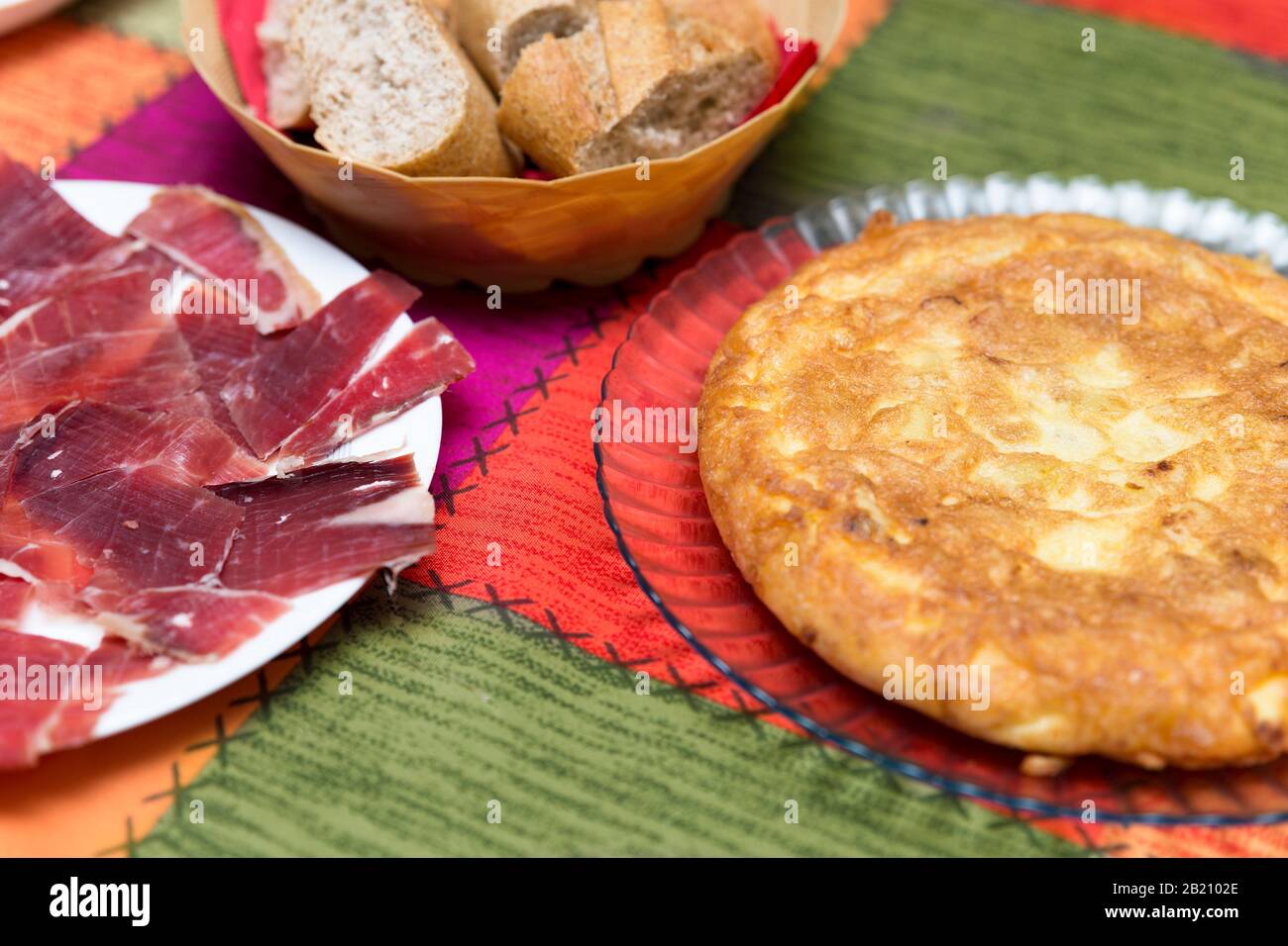 Nahaufnahme von Tellern mit spanischen Kartoffeln und Serrano-Schinken Stockfoto