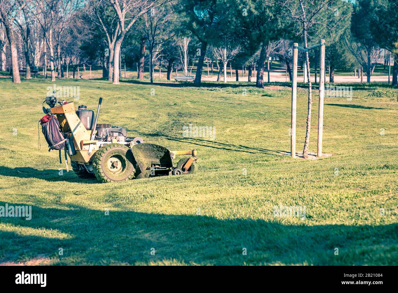 Traktor mäandrierung schmutzigen Grases nach Wartung einer Parkwiese Stockfoto