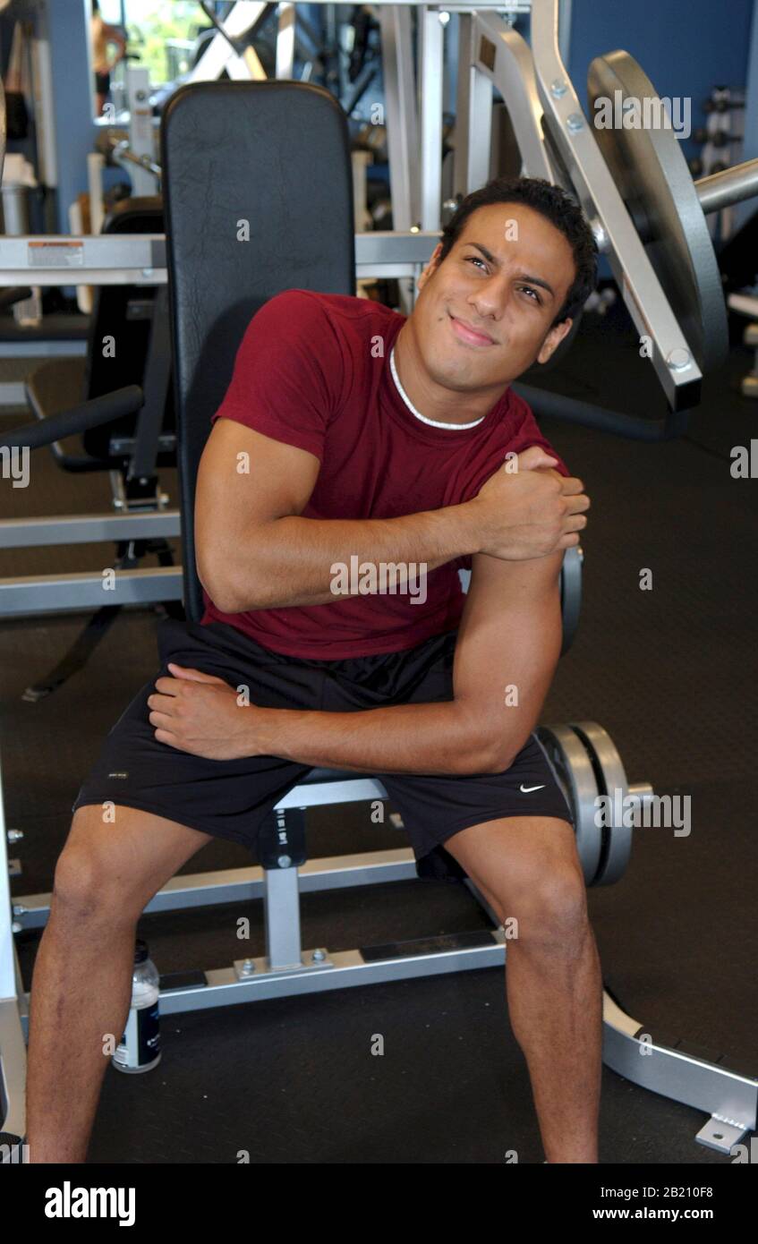 Austin, Texas: Hispanic Teen (19) nach dem Heben von Gewichten im Fitnessstudio fühlt er sich in der Schulter verkrampft. September 2004 ©Bob Daemmrich Stockfoto