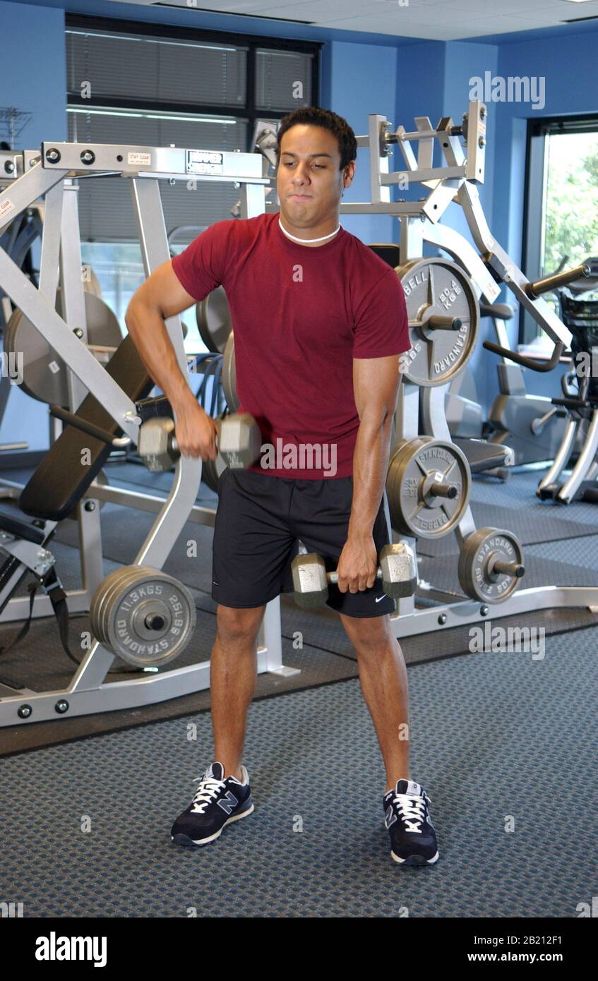 Austin, Texas Hispanic teen (19) arbeitet aus Heben von Handgewichten in einem modernen Fitnessstudio. September 2004 ©Bob Daemmrich Stockfoto