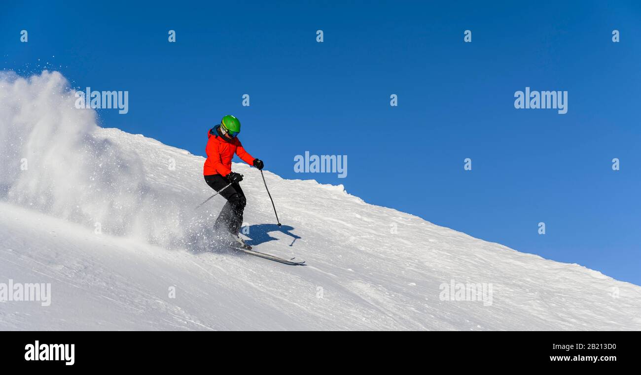 Skifahrer steigt steil ab, schwarze Piste, blauer Himmel, SkiWelt Wilder Kaiser, Brixen im Thale, Tyrol, Österreich Stockfoto