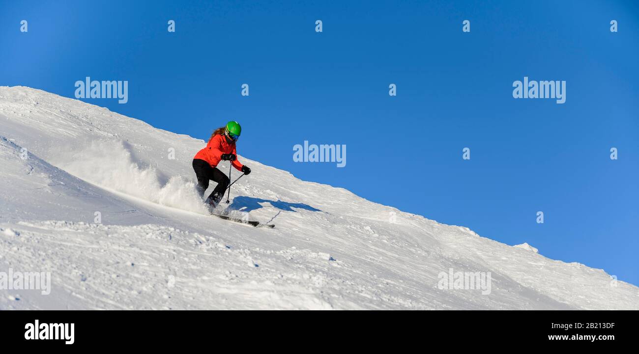 Skifahrer steigt steil ab, schwarze Piste, blauer Himmel, SkiWelt Wilder Kaiser, Brixen im Thale, Tyrol, Österreich Stockfoto