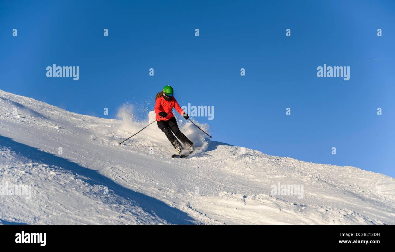 Skifahrer steigt steil ab, schwarze Piste, blauer Himmel, SkiWelt Wilder Kaiser, Brixen im Thale, Tyrol, Österreich Stockfoto