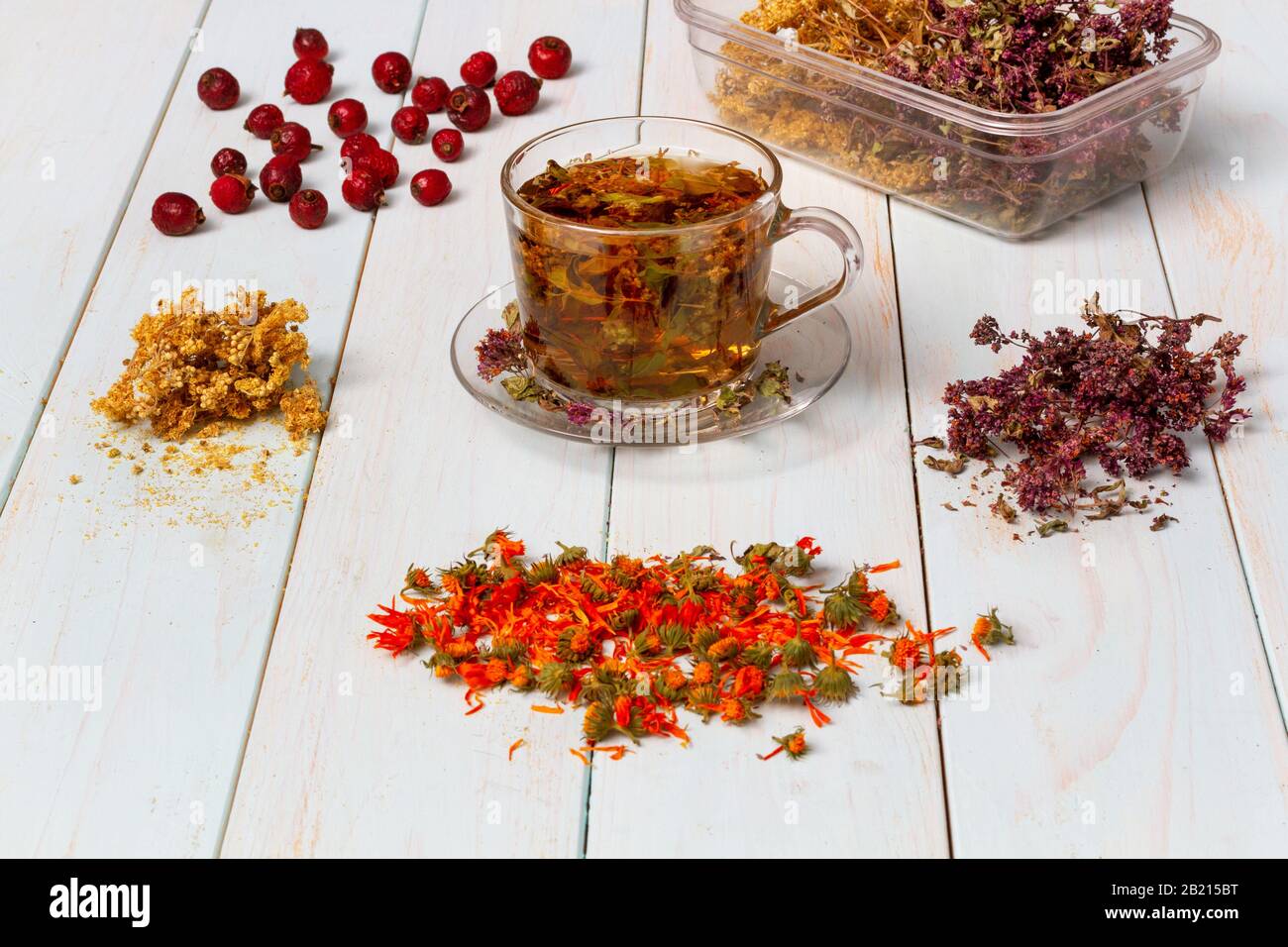 Frisch gebrühter Tee aus Heilkräutern. Getrocknete Heilkräuter für die Gesundheit. Lobaznik ordinary, oregano, marigalte Blumen, Rosehip auf einem Holztisch. Ph Stockfoto