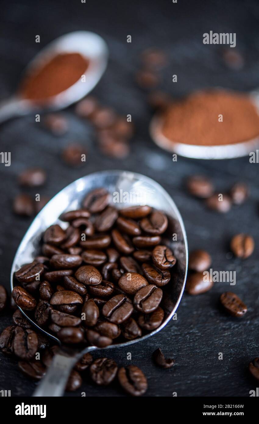 Löffel auf einem Tisch mit Kaffeebohnen und Kaffeepulver Stockfoto