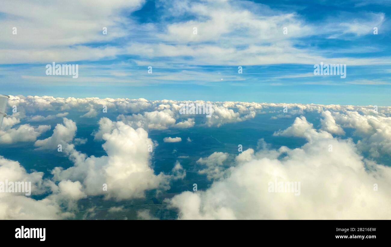 Blauer Himmel, Wolken und Boden, wenn sich das Flugzeug dem Flughafen nähert. Stockfoto