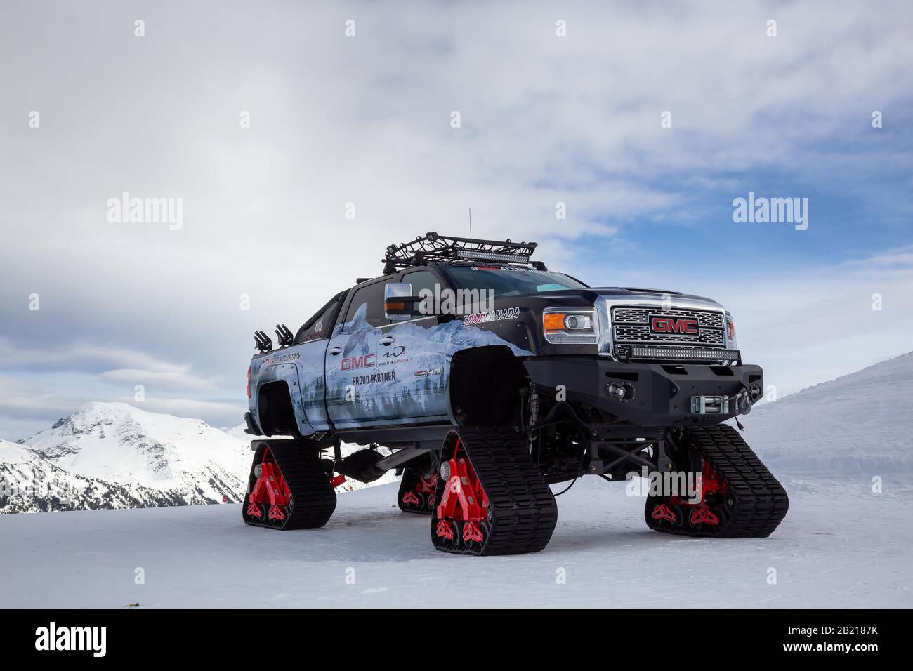 Whistler, British Columbia, Kanada - 21. Februar 2020: GMC-Truck mit Schneerägen auf einem Berg an einem bewölkten und sonnigen Tag. Stockfoto