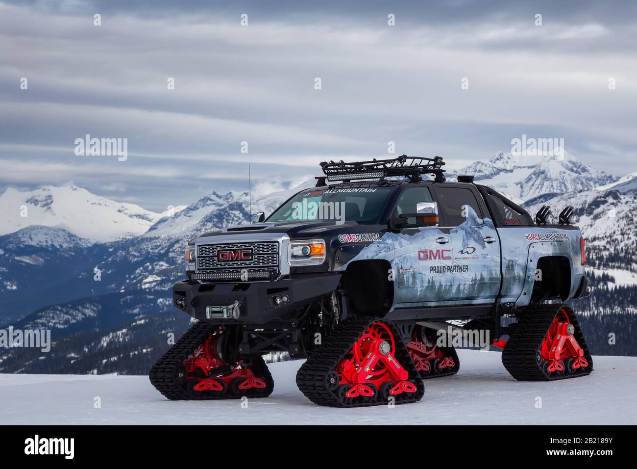 Whistler, British Columbia, Kanada - 21. Februar 2020: GMC-Truck mit Schneerägen auf einem Berg an einem bewölkten und sonnigen Tag. Stockfoto