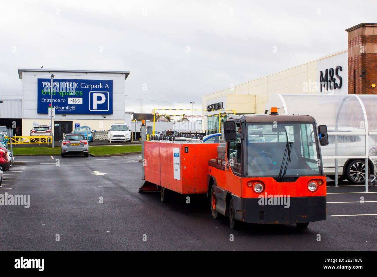 Februar 2020 EIN batteriebetriebenes Wanzi-Einkaufswagen-Rückgewinnungsfahrzeug bei der Arbeit vor Marks und Spencer im Parkplatz des Bloomfield Shopping Centers Stockfoto