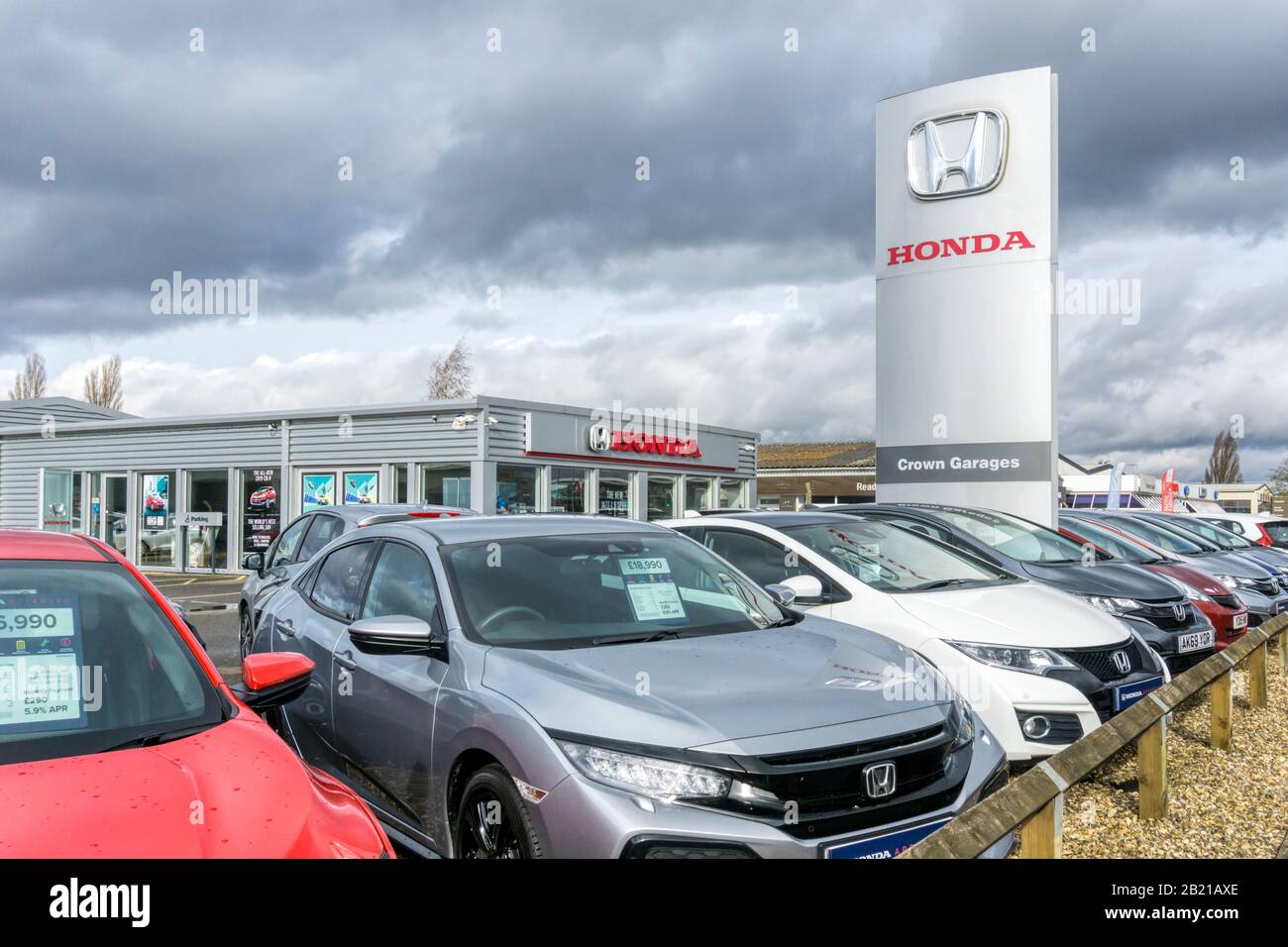Autos, die außerhalb eines Honda-Händlers mit großem Honda-Logo auf der Beschilderung verkauft werden können. Stockfoto