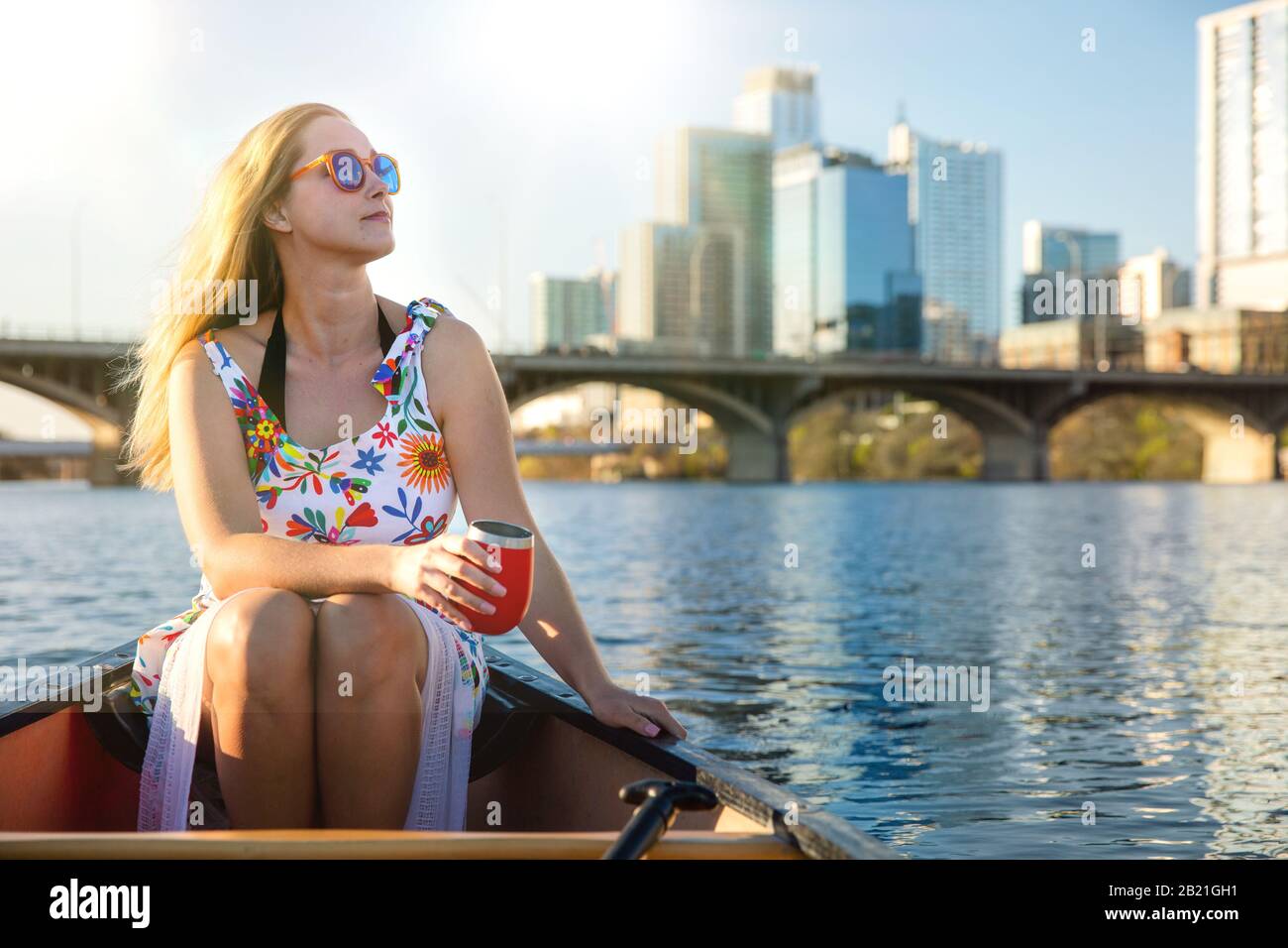 Schöne Frau an einem Sommertag, die eine entspannende Bootstour auf dem See in der amerikanischen Stadt an einem sonnigen Tag und einem entspannenden Lebensstil genießen kann Stockfoto