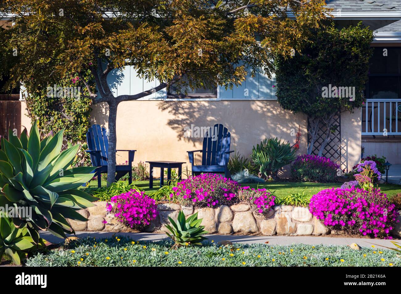 Ein Haus in Kalifornien mit zwei bemalten adirondack Stühlen und schöner, individueller Landschaftsgestaltung. Im Februar 2020 aus einem öffentlichen Raum übernommen. Stockfoto