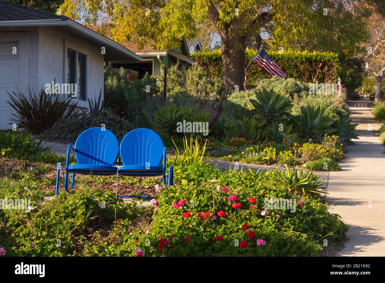 Ein Haus in Kalifornien mit zwei bemalten adirondack Stühlen und schöner, individueller Landschaftsgestaltung. Im Februar 2020 aus einem öffentlichen Raum übernommen. Stockfoto