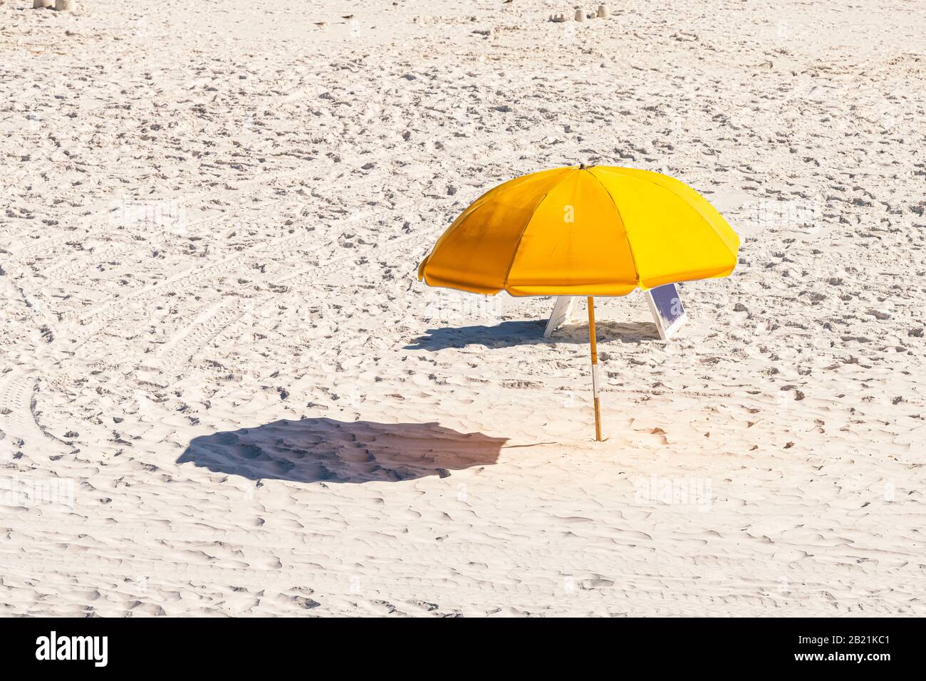 Meer, Florida Strand während des sonnigen Tages im Dorf der Stadt mit Blick auf den gelben Regenschirm und Schatten auf Sand Stockfoto