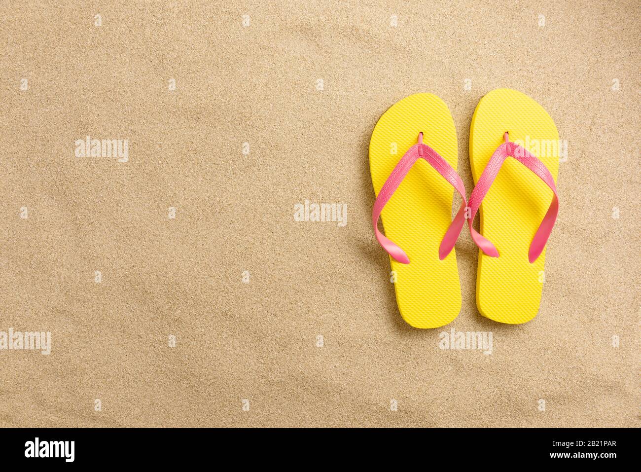 Flip-Flops auf sandigen Hintergrund. Minimales Strandkonzept .Top View mit Kopierfläche. Stockfoto