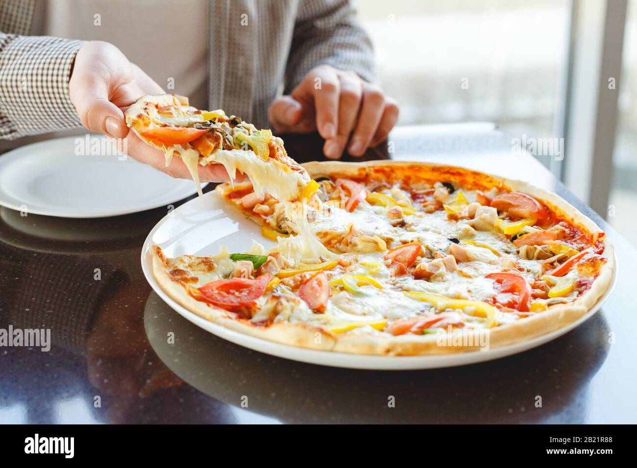 Köstliche Pizza. Kaukasianer nehmen köstliche italienische Pizza mit Mozzarella-Käse im Café, Restaurant oder zu Hause. Fast Food Pizza Stockfoto