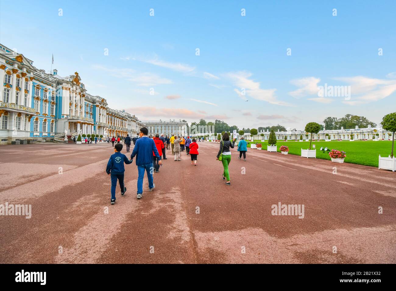 Touristen gehen über die große Promenade zwischen dem Katharinenpalast und den Gärten in Tsarskoye Selo, in der Nähe von St. Petersburg, Russland. Stockfoto