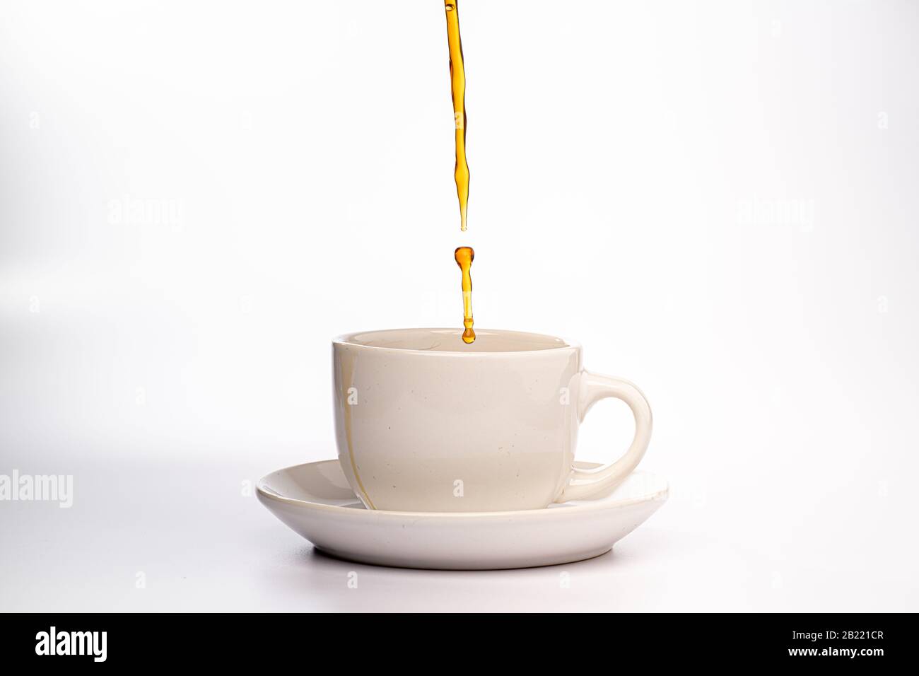 Kaffee wird in eine weiße Tasse mit Untertasse gegeben Stockfoto