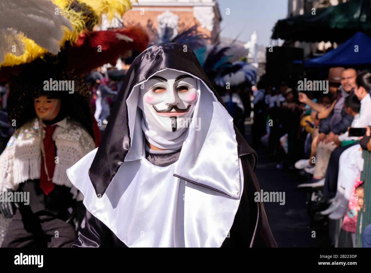 Huehue führt einen traditionellen Tanz in einem Nonnen-Outfit mit Guy Fawkes Maske auf. Tlaxcala, Mexiko, F. Stockfoto